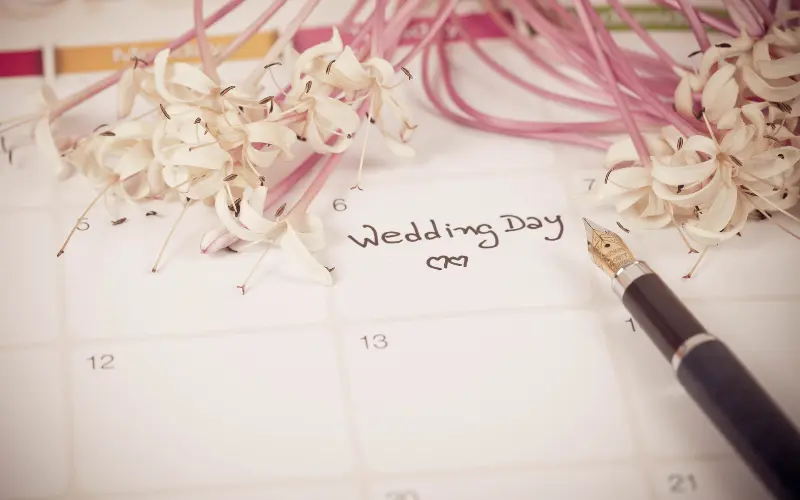 Couple planning their wedding budget together with notebook and laptop